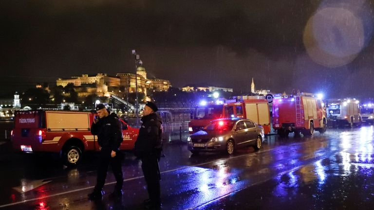 Police and fire brigade vehicles are seen on the Danube bank