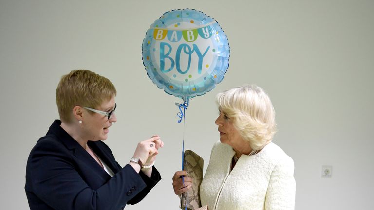 The Duchess of Cornwall receives a gift on her trip to a clinic