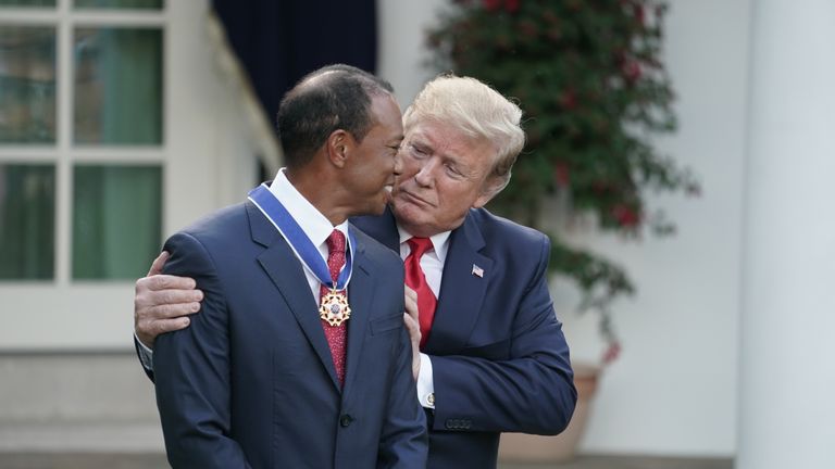 Donald Trump embraces his business and occasional golfing partner Tiger Woods