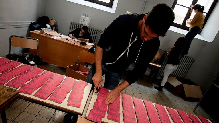 Election officials arrange the ballots of Italian parties