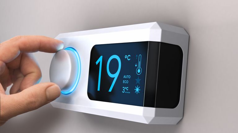 Hand turning a home thermostat knob to set temperature on energy saving mode. celcius units. Composite image between a photography and a 3D background. (Hand turning a home thermostat knob to set temperature on energy saving mode. celcius units. Compo