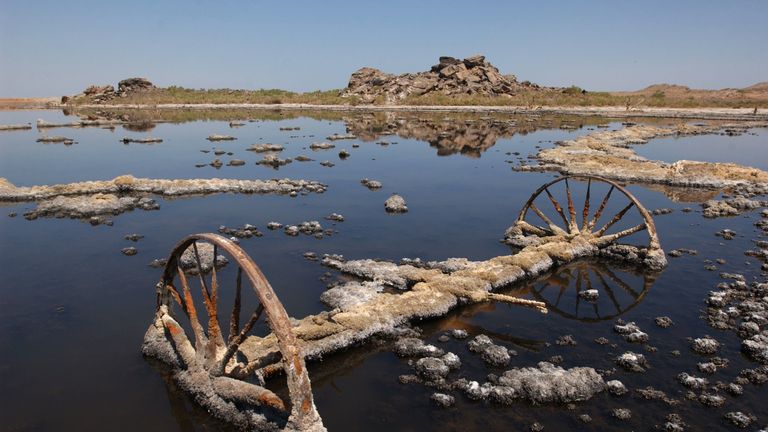 SALTON SEA, CA - JUNE 17: The wheels of an old farm machine lie rusting in the field of a farm that is encrusted with salt crystals and flooded with brine from the Salton Sea, which continually rises as a result of irrigation runoff, June 17, 2003 in the Colorado Desert of southern California. The Salton Sea Authority is considering a plan to shrink the salty 376-square-mile lake, by capturing and desalting agricultural runoff that flows into the sea from Imperial Valley farms, in an effort to r