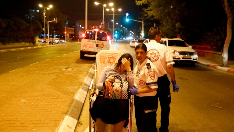 A wounded woman is evacuated from the site of rocket attack in Israel