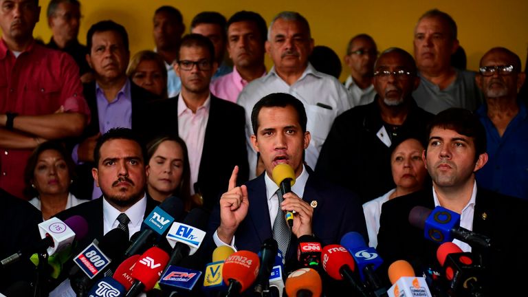 Venezuelan opposition leader Juan Guaido (C) called for peaceful demonstrations at army bases on Friday