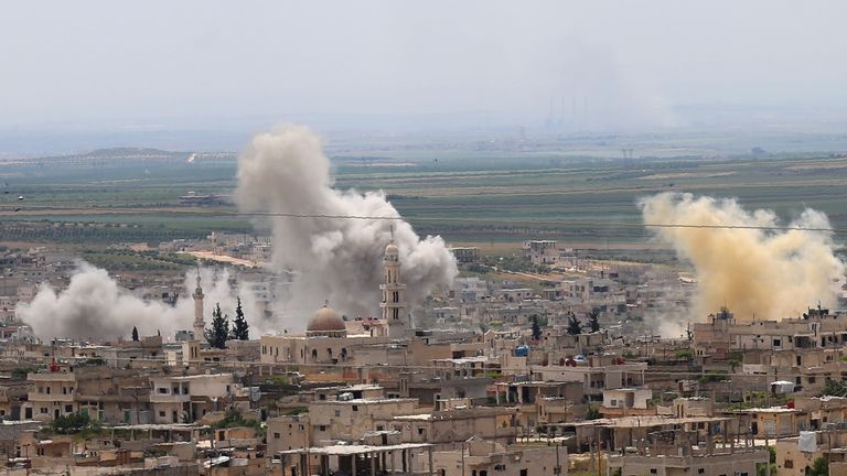 Smoke rises above buildings during shelling by Syrian regime forces and their allies on the town of Khan Sheikhun in the southern countryside of the rebel-held Idlib province on May 11, 2019