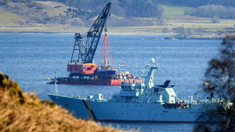 A fisheries protection vessel maneuvers near the specialist lifting barge as it recovers Fishing Trawler the Nancy Glen from Loch Fyne 