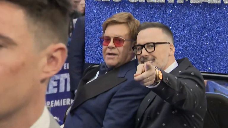 Elton John (left) arrived to the premiere with his husband David Furnish (right) on the back of a glittering golf buggy