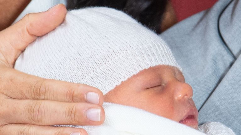 The Duchess of Sussex places her hand next to her baby son