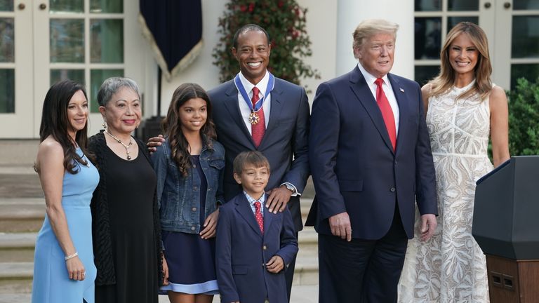 Donald and Melania Trump (right) pose with Tiger Woods (centre) and his family during the ceremony in the Rose Garden