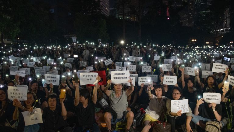 HONG KONG - JUNE 14: People hold up smartphone lights and posters during a 