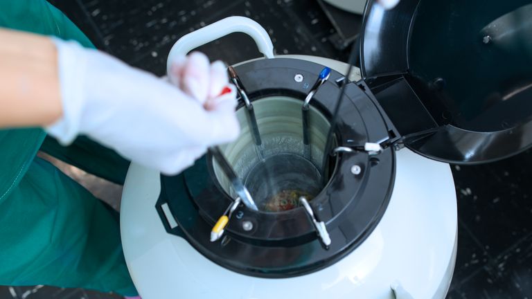 Scientist storing a sample in a canister, embryologist