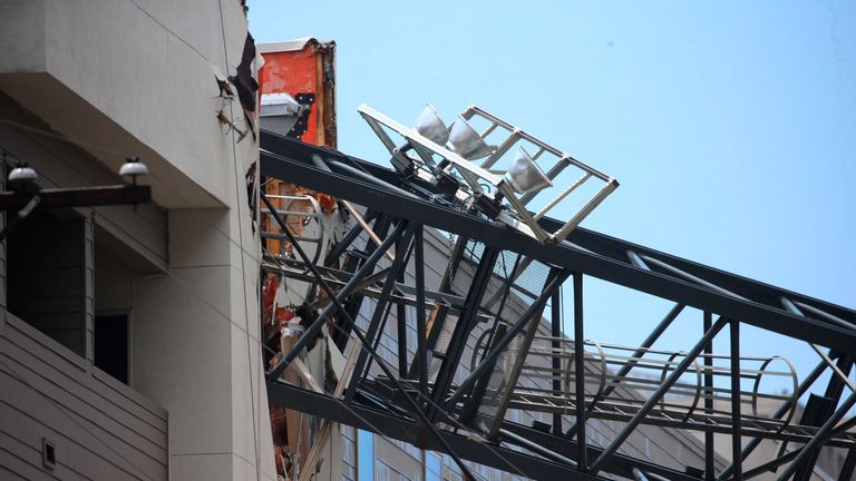 Officials respond to the scene after a crane collapsed into Elan City Lights apartments amid severe thunderstorms