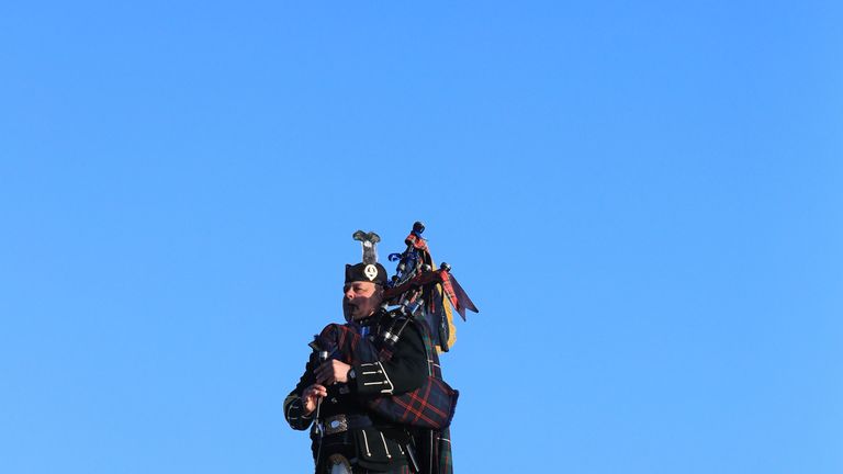A lone piper plays on the Mulberry harbour at Arromanches in Normandy