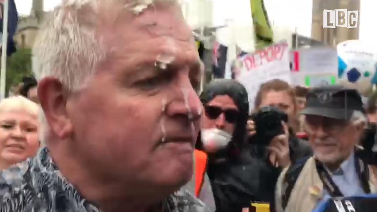 A Donald Trump supporter has had a milkshake thrown at him during mass protest against the US president&#39;s visit.