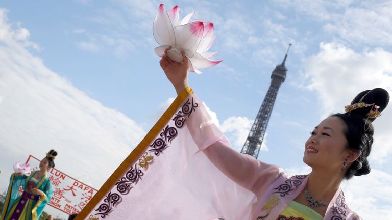 Falun Gong members perform in front of the Eiffel Tower in Paris in a protest against organ harvesting