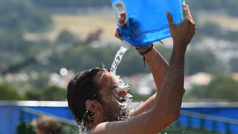 One music fan tries to keep cool by dousing himself with water