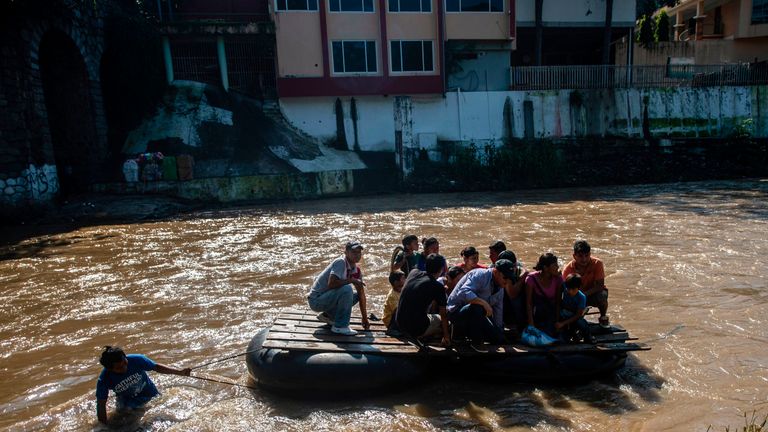 Migrants use a makeshift raft to cross the Suchiate river from El Carmen in Guatemala to Talisman in Chiapas State, Mexico