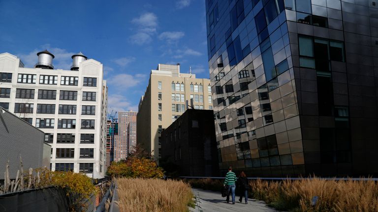 People walk along High Line park on a warm autumn day in New York
