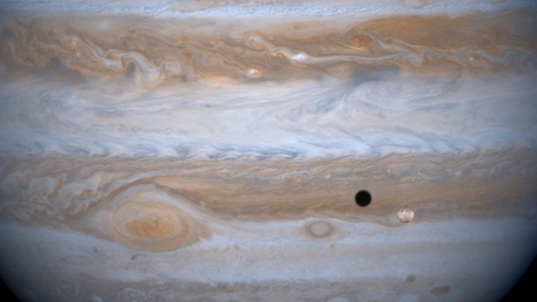 383787 01: The entire body of Moon-sized Io, as it casts a black shadow, is captured here alongside the planet Jupiter in this picture taken by NASA&#39;s Cassini spacecraft, December 3, 2000. Jupiter&#39;s other moon, Ganymede is larger than the planets Mercury and Pluto and Saturn&#39;s largest moon, Titan. Both Ganymede and Titan have greater surface area than the entire Eurasian continent on our planet. Cassini was 26.5 million kilometers (16.5 million miles) from Ganymede when this image was taken. The