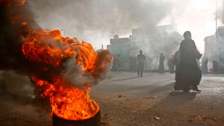 A tire burns outside army HQ in Khartoum