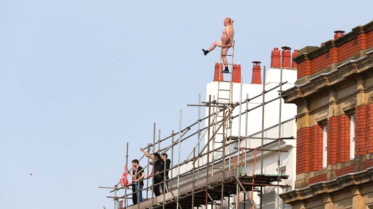 A Liverpool fan on top of scaffolding during the parade in Liverpool