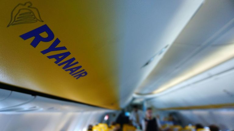  Una imagen muestra el logotipo de Ryanair mientras los pasajeros pasan a bordo de un avión de Ryanair 