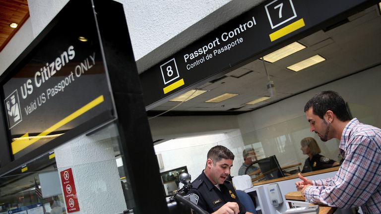MIAMI - JUNE 22: Fernando Esterlich, a Customs and Border Protection officer, checks passports at the passport control booth as people enter the United States through the Miami International Airport June 22, 2007 in Miami, Florida. The Bush administration postponed for at least six months a requirement that Americans who return to the United States by land or sea from Canada, Mexico and the Caribbean must carry passports. The rule, due to go into effect in January 2008, will be delayed until the