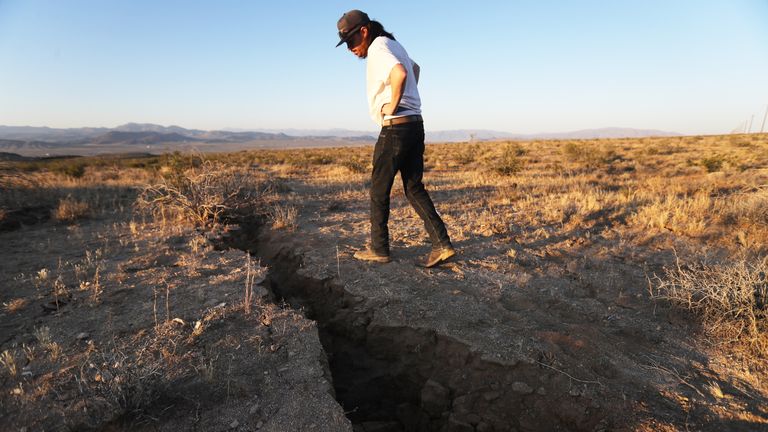 RIDGECREST, CALIFORNIA - JULY 04: A local resident inspects a fissure in the earth after a 6.4 magnitude earthquake struck the area on July 4, 2019 near Ridgecrest, California. The earthquake was the largest to strike Southern California in 20 years with the epicenter located in a remote area of the Mojave Desert. The temblor was felt by residents across much of Southern California. (Photo by Mario Tama/Getty Images)