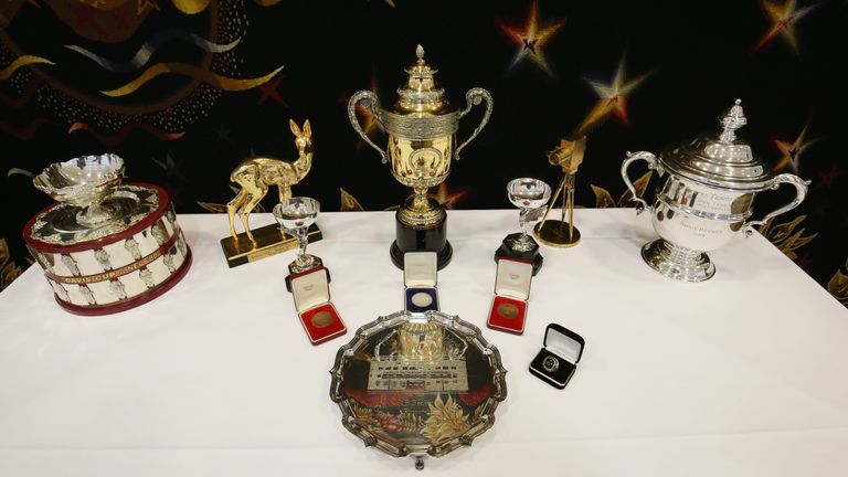 A selection of trophies, awards, and memorabilia from the tennis career of Boris Becker, including the Wimbledon singles trophy (centre top), singles runner up trophy (centre bottom), Davis Cup trophy (far left) and US Open singles trophy (far right), on show in central London before being sold.