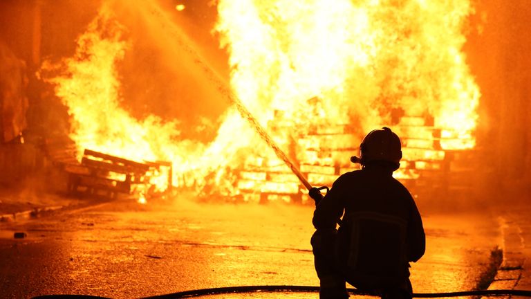 Members of the fire service work to contain an 11th night Bonfire in Cluan Place, Belfast, as hundreds of bonfires were set to be lit at midnight, as part of a loyalist tradition to mark the anniversary of the Protestant King William's victory over the Catholic King James at the Battle of the Boyne in 1690.