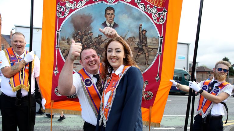 An Orange woman poses with Orange men during the annual Twelfth of July parade in Belfast, on July 12, 2019. - July 12 is the main marching day in the Protestant Orange Order calendar. The parades mark the commemoration of the victory by King William III - the Dutch-born Protestant better known as William of Orange or King Billy - over Catholic King James II at the Battle of the Boyne in 1690. (Photo by Paul Faith / AFP)        (Photo credit should read PAUL FAITH/AFP/Getty Images)