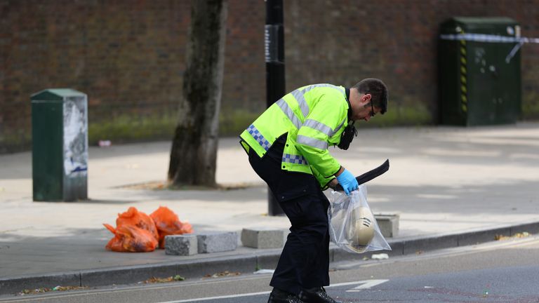 Police at the scene in Battersea, south-west London, where woman has died after being struck by a lorry while riding a scooter.