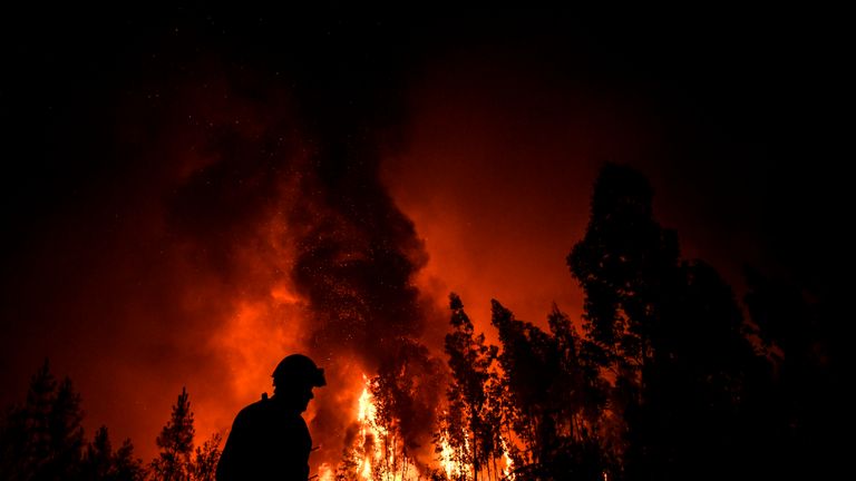 A firefighter passes while a wildfire burns the forest at Amendoa in Macao, central Portugal on July 21, 2019. - More than a thousand firefighters battled to control wildfires in central Portugal that have forced village evacuations, in a region where dozens were killed in huge blazes in 2017. The firefighters were deployed to tackle three fires in the mountainous and heavily forested Castelo Branco region, 200 kilometres north of Lisbon, according to the website of the Civil Protection. (Photo by PATRICIA DE MELO MOREIRA / AFP)        (Photo credit should read PATRICIA DE MELO MOREIRA/AFP/Getty Images)