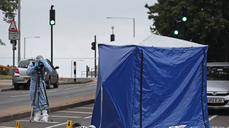 A forensics officer on Moor Lane in Chessington following a hit-and-run incident where a man died after being "dragged under a car".