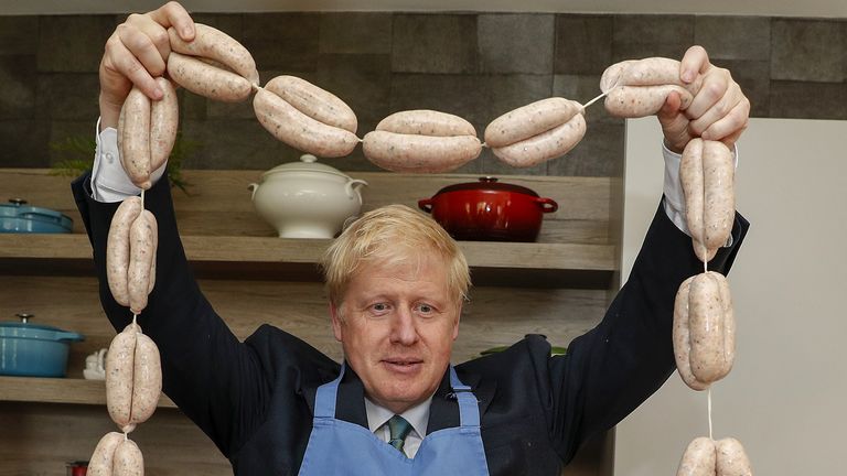 Conservative party leadership candidate Boris Johnson holds up a string of sausages around his neck during a visit to Heck Foods Ltd. 