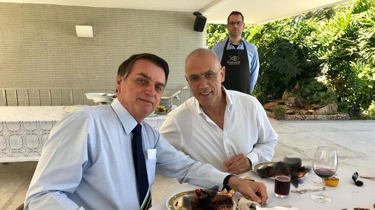 Mr Bolsonaro (left) was eating with his country's ambassador to Israel