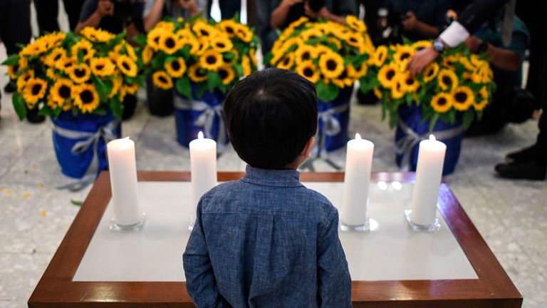 A boy stands in front of candles and flowers during a commemoration ceremony for passengers who perished aboard flight Malaysia Airlines flight MH17, which was shot down over eastern Ukraine five years ago at the Australian High Commission in Kuala Lumpur on July 17, 2019. (Photo by MOHD RASFAN / AFP) (Photo credit should read MOHD RASFAN/AFP/Getty Images)