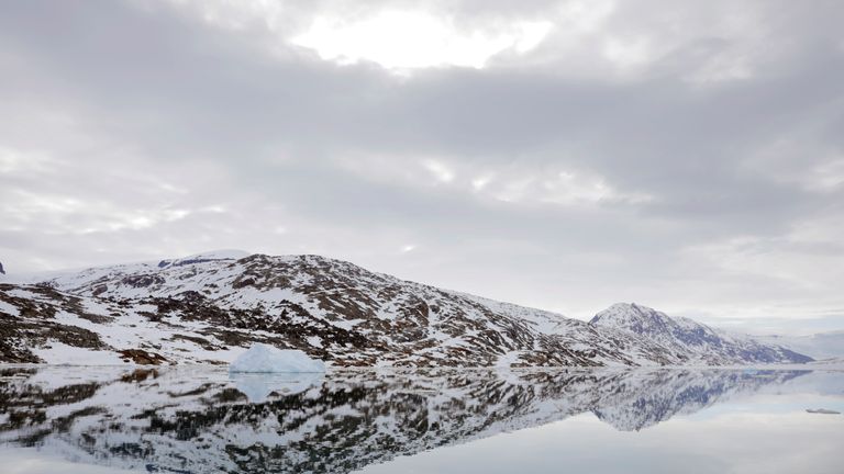 The snow-covered shore is reflected in the still water of a fjord near Tasiilaq, Greenland, June 16, 2018. REUTERS/Lucas Jackson SEARCH "JACKSON TASIILAQ" FOR THIS STORY. SEARCH "WIDER IMAGE" FOR ALL STORIES.