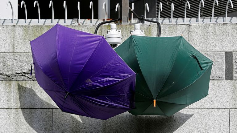 Umbrellas are hung over CCTV cameras during a protest