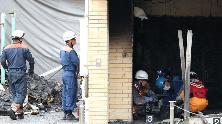 Investigators inspect the scene where 33 people died in a fire at the Kyoto Animation company building 