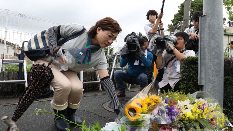 Residents place flowers for victims of the fire