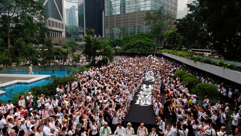 The ederly protesters dressed in white tops and black trousers