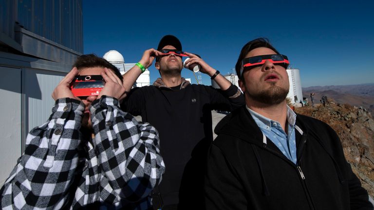 People watch a solar eclipse at La Silla European Southern Observatory (ESO) in La Higuera, Coquimbo Region, Chile, on July 02, 2019. - Tens of thousands of tourists braced Tuesday for a rare total solar eclipse that was expected to turn day into night along a large swath of Latin America's southern cone, including much of Chile and Argentina