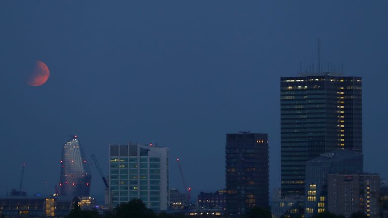 A partial lunar eclipse is visible above London from Primrose Hill, on the 50th anniversary of Apollo 11 launching on its moon mission