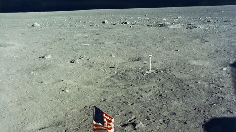 The United States flag is planted on the surface of the Moon by the astronauts of NASA's Apollo 11 lunar landing mission, as seen from inside the Lunar Module the 'Eagle', 20th July 1969. In the background is the black and white lunar surface television camera which televised astronauts Neil Armstrong and Edwin 'Buzz' Aldrin Jr during their EVA (extravehicular activity). (Photo by Space Frontiers/Getty Images) 