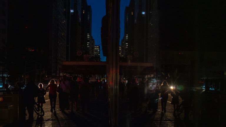 A woman sits inside a Duane Read on 57th Street attempting to use her cell phone during a major power outage on July 13, 2019 in New York City