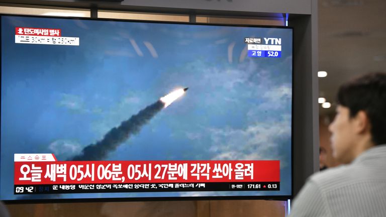 A man watches file footage of a previous North Korean missile launch