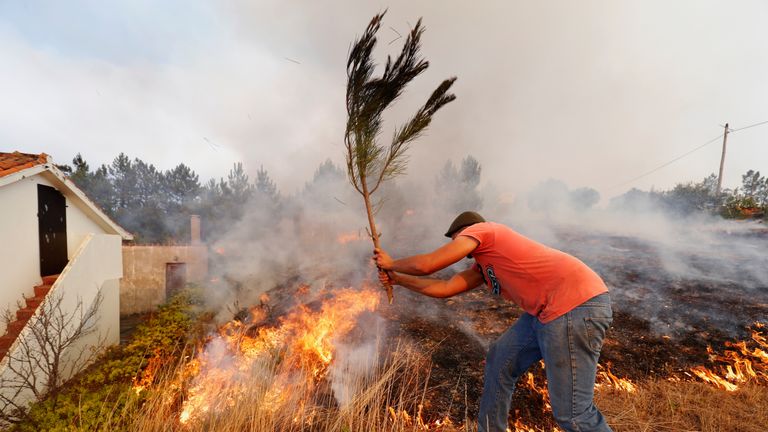 Villagers help to put out a forest fire at the small village of Colos, Portugal 