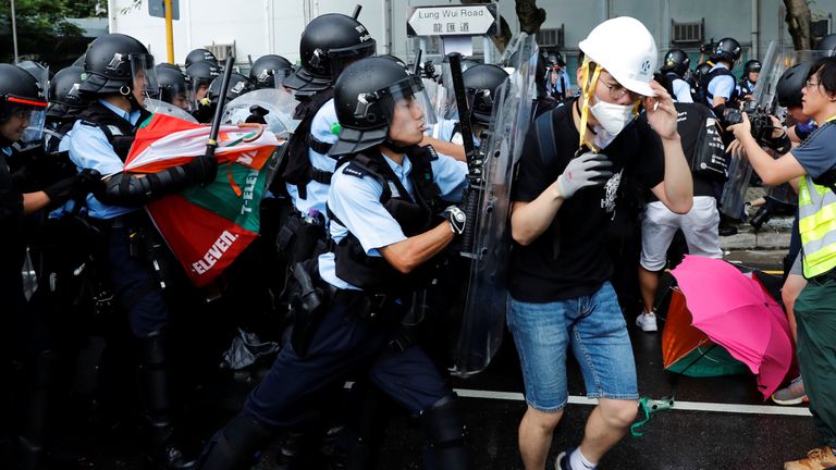 Police try to disperse protesters near a flag raising ceremony for the anniversary of Hong Kong handover to China