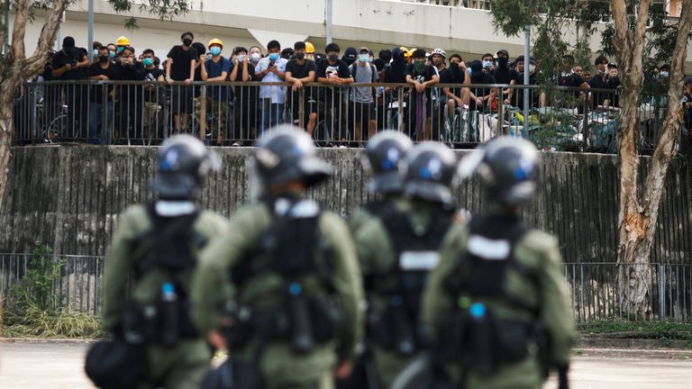 Riot police watch as protesters gather in Yuen Long